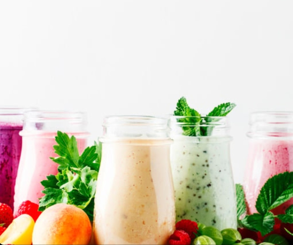 Colourful fruit smoothies in glass bottles